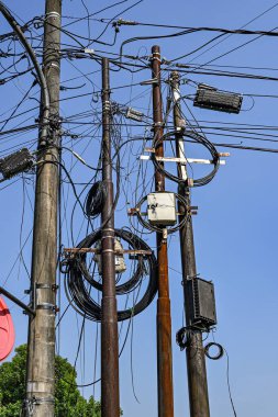 Bir grup elektrik hattı birbirine dolanmış ve gökyüzü mavi