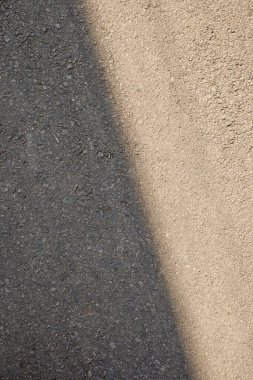 Yolun ortasında beyaz bir çizgi olan siyah beyaz bir fotoğraf. Fotoğrafın karamsar, kasvetli bir havası var.