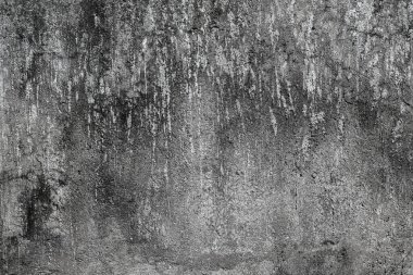 Bir sürü çatlağı ve deliği olan gri bir duvar. Duvar eski ve yıpranmış.