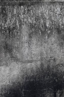 Bir sürü çatlağı ve deliği olan gri bir duvar. Duvar eski ve yıpranmış.