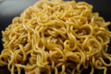 Bir tabak hazır şehriye masanın üzerinde duruyor. Erişteler uzun ve ince ve tabakta üst üste yığılmış. Bolluk ve hoşgörü kavramı