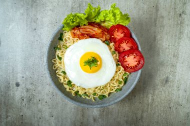 Yumurtalı, domatesli ve marullu bir kase hazır erişte.