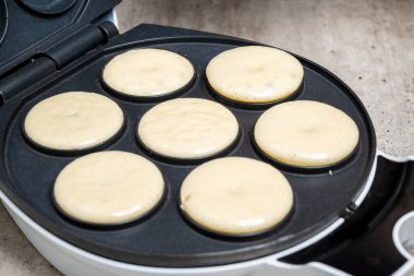 Donut yapmak için bir waffle ızgarası kullanılıyor. Donutlar altın sarısı ve servis edilmeye hazır.