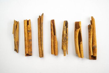 Tarçın çubukları yakın plan. Çubuklar ikiye bölündü ve sıra sıra dizildi. Sıcaklık ve rahatlık kavramı, tarçın sıkça sıcacık ve rahatlatıcı kokularla ilişkilendirilir.