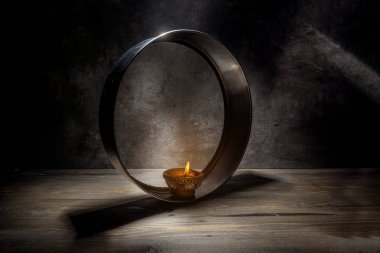 Kevgir üzerinde Diya yağı lambası. Mum yanıyor ve ışık ağ boyunca parlıyor, sıcak ve rahat bir atmosfer yaratıyor. Karva Chauth festivali konsepti