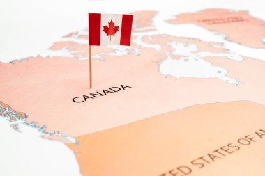 Üzerinde Kanada bayrağı olan bir Kanada haritası. Akçaağaç yaprağı, kırmızı ve beyaz renkli bayrak. Seyahat ve hükümet kavramı