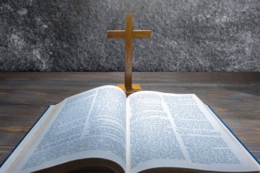 Ahşap din haçı ve Kutsal İncil 'in mavi kitabını açtı. Hıristiyan geçmişi, ibadet, kilise, semboller, dua kavramı. Tanrıya olan inancın sembolü, Hıristiyanlık ziyafeti, Paskalya Bayramı, Kutsal Cuma, Palm Sunday