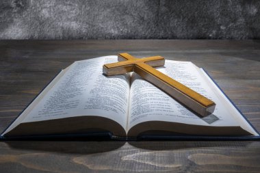 Ahşap din haçı ve Kutsal İncil 'in mavi kitabını açtı. Hıristiyan geçmişi, ibadet, kilise, semboller, dua kavramı. Tanrıya olan inancın sembolü, Hıristiyanlık ziyafeti, Paskalya Bayramı, Kutsal Cuma, Palm Sunday