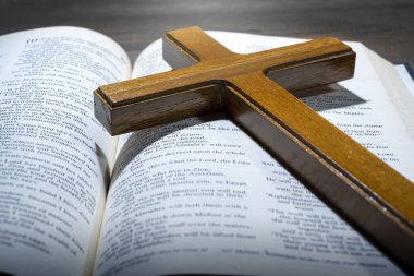Ahşap din haçı ve Kutsal İncil 'in mavi kitabını açtı. Hıristiyan geçmişi, ibadet, kilise, semboller, dua kavramı. Tanrıya olan inancın sembolü, Hıristiyanlık ziyafeti, Paskalya Bayramı, Kutsal Cuma, Palm Sunday