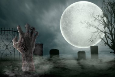 Mezarlıkta kanlı bir yara almış bir zombi eli var. Şeytan, şeytan, şeytan ya da canavar eli gibi görünüyor. Korkunç ve ürkütücü Cadılar Bayramı konsepti