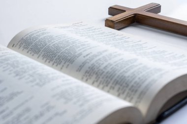Tahta din haçı ve beyaz arka planda izole edilmiş İncil 'in mavi kitabı. Tanrı 'ya olan inancın sembolü, Hıristiyanlık ziyafeti. Dindar Hıristiyan bayramı ya da konsepti