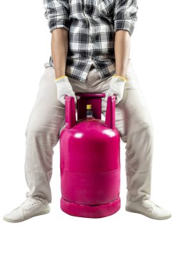 Bir adam beyaz arka planda izole edilmiş pembe bir gaz tüpü taşıyor. Ekose gömlek, eldiven ve beyaz pantolon giyiyor.