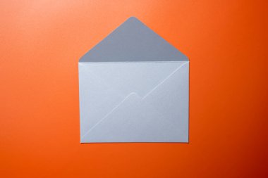 Boş beyaz zarf ve renkli arkaplanda kartpostalın üst görüntüsü. Model, kopyalama alanı. Düz yatış biçimine sahip tebrik ya da davet kartı