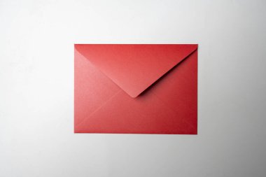 Kırmızı zarfın üst görüntüsü ve beyaz arka planda kartpostal. Model, boş şablon, kopyalama alanı. Düz yatış biçimine sahip tebrik ya da davet kartı