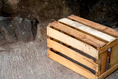 Beton zemin üzerinde taş duvar zeminli tahta sandık. Tahta palet kutusu. Sandık boş ve tahtadan yapılmış. Yaşlı ve yıpranmış