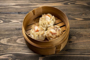 Tahta masadaki bambu ahşap kasede Çin Dim Sum köftesi. Kahvaltı, öğle yemeği ya da akşam yemeği. Çin ya da Ay Yeni Yıl Dekorasyonu