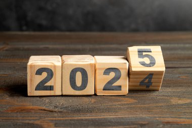 Tahta bloklar 2024 'ten 2025' e masada dönüşür. Mutlu yıllar ya da yeni yıl kutlamaları