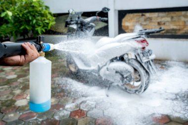 Profesyonel işçi el temizleme köpüğüyle motosikleti yıkıyor. Araç yıkama profesyonel hizmet