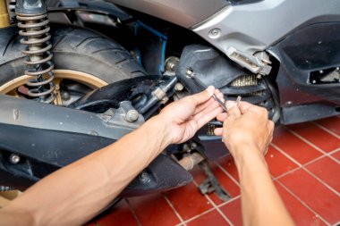 Motosiklet tamircisi garajda motosikleti tamir ediyor. Motosiklet tamiri, bakım ve servis kavramı