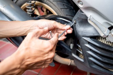 Motosiklet tamircisi garajda motosikleti tamir ediyor. Motosiklet tamiri, bakım ve servis kavramı