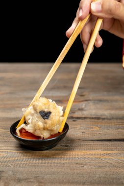 Çubuklu Çinli, Çin usulü Çin mantısı ve sos yiyor. Kahvaltı, öğle yemeği ya da akşam yemeği. Çin ya da Ay Yeni Yıl Dekorasyonu