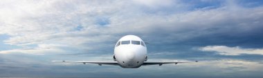 Gökyüzünde uçan ticari uçağın arka planında bulutlar var. Uçak konseptiyle seyahat