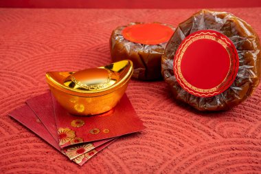 Çin Yeni Yıl pirinç keki ya da kırmızı arka planda angpao ve Çin altınlı Nian Gao. Kue Keranjang ya da Dodol China olarak da bilinir. Çin ya da Ay Yeni Yılını kutlamak için yiyecek.