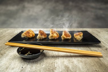 Çin usulü kızarmış hamur tatlısı, gyoza, jiaozi ya da tabakta yemek çubukları ve soya sosuyla birlikte mandu. Kahvaltı, öğle yemeği ya da akşam yemeği. Çin ya da Ay Yeni Yıl Dekorasyonu