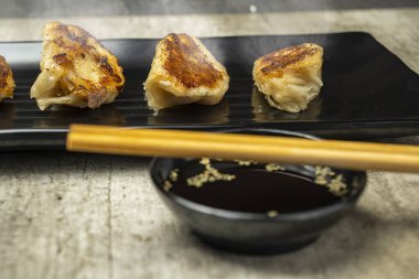 Çin usulü kızarmış hamur tatlısı, gyoza, jiaozi ya da tabakta yemek çubukları ve soya sosuyla birlikte mandu. Kahvaltı, öğle yemeği ya da akşam yemeği. Çin ya da Ay Yeni Yıl Dekorasyonu