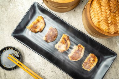 Çin usulü kızarmış hamur tatlısı, gyoza, jiaozi ya da tabakta yemek çubukları ve soya sosuyla birlikte mandu. Kahvaltı, öğle yemeği ya da akşam yemeği. Çin ya da Ay Yeni Yıl Dekorasyonu