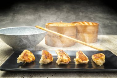 Kızarmış Çin Dim Sum köftesi, gyoza, jiaozi ya da tabakta kase ve masada bambu ahşap bir sepet. Kahvaltı, öğle yemeği ya da akşam yemeği. Çin ya da Ay Yeni Yıl Dekorasyonu