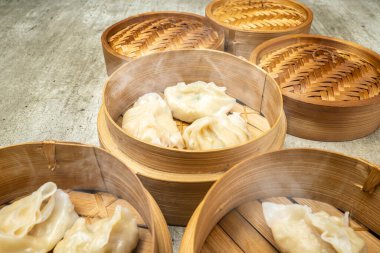 Tahta masadaki bambu ahşap sepet kasesinde Çin Dim Sum hamur tatlısı. Kahvaltı, öğle yemeği ya da akşam yemeği. Çin ya da Ay Yeni Yıl Dekorasyonu