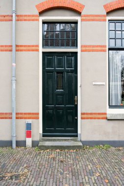 Hollanda, Amsterdam 'da camlı ve siyah ön kapılı evin ön cephesi. İnşaat ve mimari arka plan