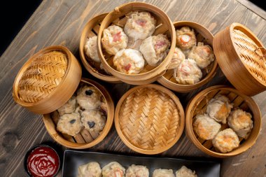 Tabakta Çin Dim Sum köfteleri, sos ve ahşap masada bambu sepet. Kahvaltı, öğle yemeği ya da akşam yemeği. Çin ya da Ay Yeni Yıl Dekorasyonu