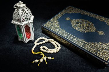 Dua boncuklu Arapça fener ve siyah zemin üzerine Kur 'an. Müslüman bayramı kutlaması için dekorasyon. İslami oruç, Ramazan Kareem, Kurban Bayramı, Kurban Bayramı veya Mübarek selamlar