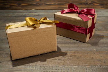 Kahverengi hediye kutuları ahşap bir masada renkli bir kurdeleyle bağlanmış. Model ya da kopyalama alanı. Tatil, yıldönümü, kutlama, hediye ya da sürpriz için dekorasyon kavramı