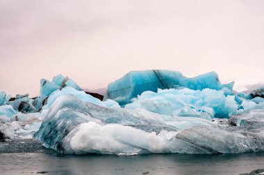 İzlanda 'daki Jokulsarlon Buzul Gölü' ndeki eriyen buzulun görüntüsü. Doğa, seyahat, iklim değişikliği, küresel ısınma, kış arkaplanı veya duvar kağıdı