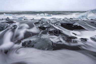 Jokulsarlon, İzlanda 'daki elmas plajındaki eriyen buzulun manzarası. Doğa, seyahat, iklim değişikliği, küresel ısınma, kış arkaplanı veya duvar kağıdı