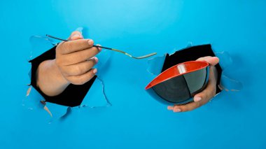 Bir insan eli çatal tutuyor ve kağıt parçalarına ayırıyor. El hareketleri yiyeceğe ulaşmak ya da kapmak için. Boşluk oluştur ya da kopyala