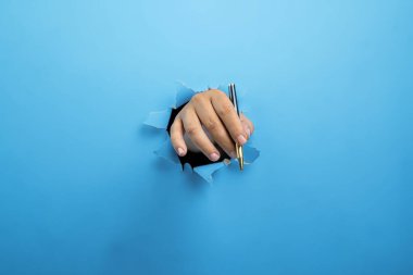 İnsan eli tükenmez kalemle yırtılmış kağıdı tutuyor. Model veya Kopyala uzayı. İş kavramı, imza, iletişim veya el yazısı