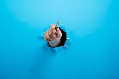 İnsan eli tükenmez kalemle yırtılmış kağıdı tutuyor. Model veya Kopyala uzayı. İş kavramı, imza, iletişim veya el yazısı