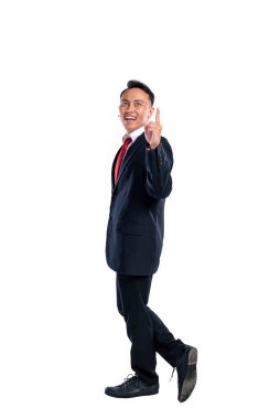 Asyalı bir işadamının portresi beyaz bir arkaplan üzerine izole edilmiş işaret eden bir el hareketiyle duruyor. Uzayı kopyala İş kavramı, girişimci ve başarılı.