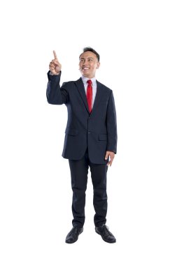 Asyalı bir işadamının portresi beyaz bir arkaplan üzerine izole edilmiş işaret eden bir el hareketiyle duruyor. Uzayı kopyala İş kavramı, girişimci ve başarılı.
