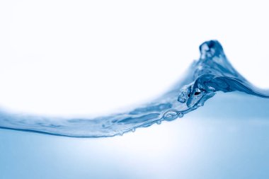 Beyaz zemin üzerinde dinamik akan mavi su dalgalarının yakın görüntüsü. Sıvı sıçraması. Doku ve soyut arkaplan