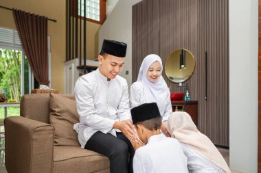 Mübarek bayramını kutlarken Endonezyalı Müslüman çocuğun ailesi için af dileyen portresi. Mutlu Lebaran, Kurban Bayramı, İdul Fitri ve Ramazan Mübarek kutlamaları.