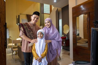 Kurban namazından sonra Endonezyalı Müslüman ailenin portresi evin içinde. Mutlu Lebaran, Kurban Bayramı, İdul Fitri ve Ramazan Mübarek kutlamaları.