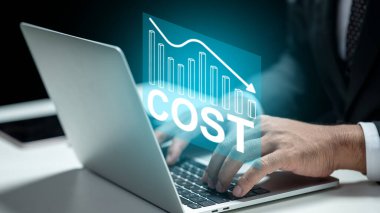 Düşük maliyetli bir çizelgeyle dizüstü bilgisayarda yazan bir işadamı. Sanal ekranda teknolojik yenilik. Maliyet azaltma, iş performans yönetimi ve iyileştirme kavramı