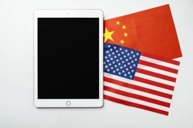 Amerika 'nın bayrakları Çin' e karşı ve boş ekranlı bir tablet. Model ya da kopyalama alanı. Amerika Birleşik Devletleri kavramı ile Çin arasındaki ticaret anlaşmazlığı veya ekonomik çatışma