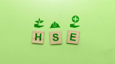 Yeşil arka planda HSE işareti olan tahta küpler. Sağlık, Güvenlik ve Çevrenin kısaltılmışı. Güvenli, sağlıklı ve iyi bir ortamın endüstri standartlaşması