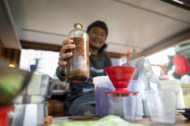 Siparişi açmadan önce Endonezyalı güneydoğu Asyalı barista kahvecisini hazırlıyor. Kamyon üzerinde küçük bir kafe ya da kafe işletmesi